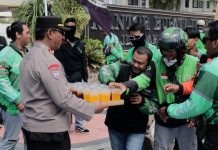 Humanis Polisi Kawal Aksi Damai Driver Ojol di Jember Sambil Berbagi Minuman Dingin
